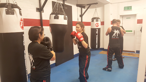 Group of students practice on puch bags  at Boilerhouse Gym Isleworth