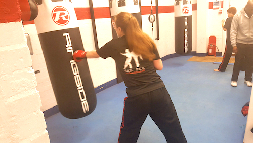 A female student pratcrices on punch bag at Isleworth Boilerhouse Gym
