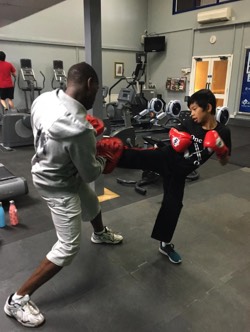 Rob practisces kick boxing fitness training with a young student as part of the boxing personal taining programme at Richmond Olympus Gym